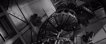 Movie still from “The Haunting” (1963), directed by Robert Wise – A black and white photo of a spiral staircase; Wide shot, Low angle