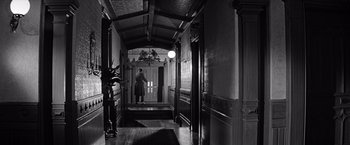 Movie still from “The Haunting” (1963), directed by Robert Wise – A person walking down a hall way in a building; Wide shot, Low angle