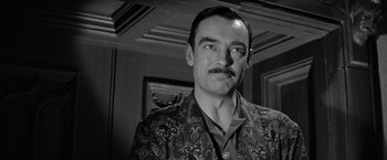 Movie still from “The Haunting” (1963), directed by Robert Wise – A man with a mustache wearing a suit; Close Up shot, Over the shoulder angle