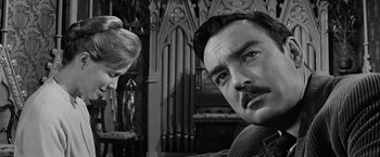 Movie still from “The Haunting” (1963), directed by Robert Wise – A black and white photo of a man and a woman in front of an altar; Close Up shot, Low angle