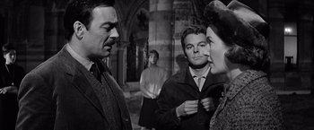 Movie still from “The Haunting” (1963), directed by Robert Wise – A group of people standing around each other in front of a building; Medium shot, Over the shoulder angle