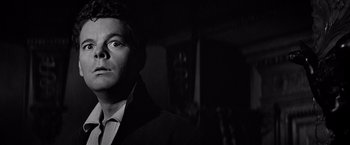 Movie still from “The Haunting” (1963), directed by Robert Wise – A black and white photo of a man in a suit and tie; Close Up shot, Low angle