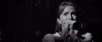 Movie still from “The Haunting” (1963), directed by Robert Wise – A black - and - white photo of a woman holding her hands to her mouth; Close Up shot, Over the shoulder angle
