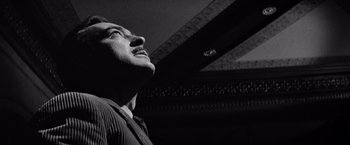 Movie still from “The Haunting” (1963), directed by Robert Wise – A black and white photo of a man looking up; Close Up shot, Low angle