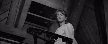Movie still from “The Haunting” (1963), directed by Robert Wise – A woman in a white dress standing next to a railing; Close Up shot, Low angle