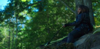A person holding a stick in a forest