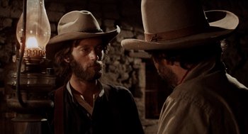 Movie still from “The Hired Hand” (1971), directed by Peter Fonda – Two men in cowboy hats talking to each other; Close Up shot, Over the shoulder angle