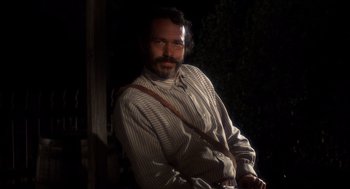Movie still from “The Hired Hand” (1971), directed by Peter Fonda – A man with a beard and a striped shirt is posing for a picture; Close Up shot, Low angle