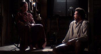 Movie still from “The Hired Hand” (1971), directed by Peter Fonda – A man and a woman sitting on the floor in front of each other; Medium shot, Over the shoulder angle