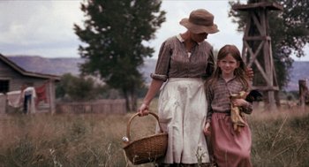 Movie still from “The Hired Hand” (1971), directed by Peter Fonda – An older woman and a young girl holding a basket in a field; Wide shot, Low angle