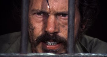 Movie still from “The Hired Hand” (1971), directed by Peter Fonda – A person behind a fence; Close Up shot, Low angle