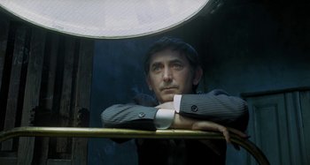 A man leaning on a railing in front of an umbrella