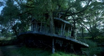 Movie still from “The Hourglass Sanatorium” (1973), directed by Wojciech Has – An abandoned house with a tree growing over it; Extreme Wide shot, Low angle