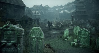 A man is walking through a graveyard in the rain