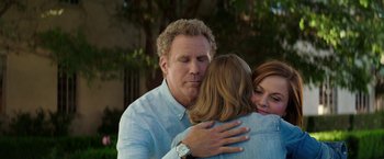 Movie still from “The House” (2017), directed by Andrew Jay Cohen – A man and two women hugging each other outside; Medium shot, Over the shoulder angle