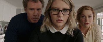 Movie still from “The House” (2017), directed by Andrew Jay Cohen – A man and a woman wearing glasses looking at the camera; Close Up shot, Over the shoulder angle