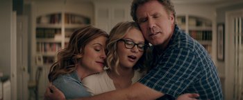 Movie still from “The House” (2017), directed by Andrew Jay Cohen – Two women and a man are hugging each other; Close Up shot, Overhead angle