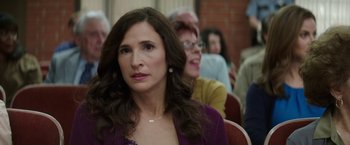 Movie still from “The House” (2017), directed by Andrew Jay Cohen – A person sitting in front of a group of people; Close Up shot, Over the shoulder angle