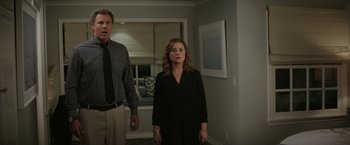 Movie still from “The House” (2017), directed by Andrew Jay Cohen – A man and a woman standing next to each other in a room; Medium shot, Over the shoulder angle