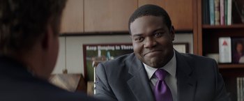 Movie still from “The House” (2017), directed by Andrew Jay Cohen – A person wearing a suit and tie; Close Up shot, Over the shoulder angle