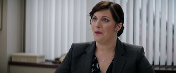 Movie still from “The House” (2017), directed by Andrew Jay Cohen – A person wearing a suit; Close Up shot, Over the shoulder angle