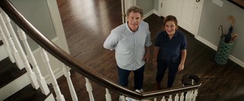 Movie still from “The House” (2017), directed by Andrew Jay Cohen – A man and a woman standing at the top of a staircase; Wide shot, Overhead angle
