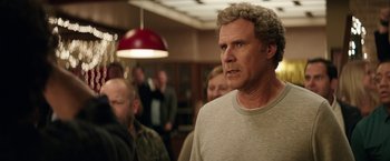 Movie still from “The House” (2017), directed by Andrew Jay Cohen – A person standing in front of a group of people; Medium shot, Over the shoulder angle