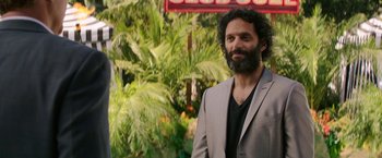 Movie still from “The House” (2017), directed by Andrew Jay Cohen – A man with a beard and a suit and tie; Close Up shot, Over the shoulder angle