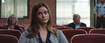 Movie still from “The House” (2017), directed by Andrew Jay Cohen – A woman sitting in a chair with a bruise on her face; Close Up shot, Over the shoulder angle