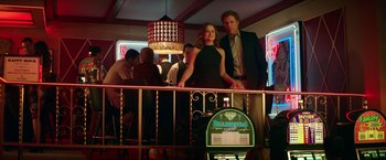 Movie still from “The House” (2017), directed by Andrew Jay Cohen – A man and a woman standing on a railing in a bar; Wide shot, Low angle