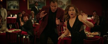 Movie still from “The House” (2017), directed by Andrew Jay Cohen – A man and a woman are standing in front of each other; Medium shot, Over the shoulder angle