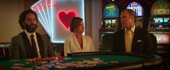 Movie still from “The House” (2017), directed by Andrew Jay Cohen – A woman sitting at a table in front of cards; Medium shot, Over the shoulder angle