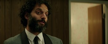 Movie still from “The House” (2017), directed by Andrew Jay Cohen – A bearded man in a suit and tie; Close Up shot, Low angle