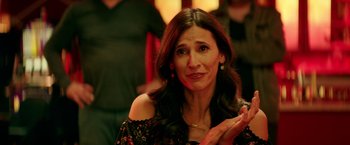 Movie still from “The House” (2017), directed by Andrew Jay Cohen – A woman claps her hands while sitting in a room; Close Up shot, Over the shoulder angle