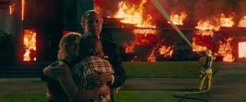 Movie still from “The House” (2017), directed by Andrew Jay Cohen – A man and a woman hug in front of an exploding building; Medium shot, Over the shoulder angle