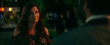 Movie still from “The House” (2017), directed by Andrew Jay Cohen – A woman standing in front of a group of people in a park; Close Up shot, Over the shoulder angle