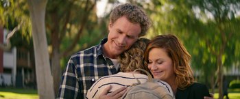 Movie still from “The House” (2017), directed by Andrew Jay Cohen – A man and a woman hugging a woman in a striped shirt; Medium shot, Over the shoulder angle