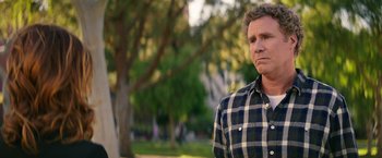 Movie still from “The House” (2017), directed by Andrew Jay Cohen – A person wearing a plaid shirt near a tree; Close Up shot, Over the shoulder angle