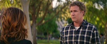 Movie still from “The House” (2017), directed by Andrew Jay Cohen – A person wearing a plaid shirt near a tree; Medium shot, Over the shoulder angle