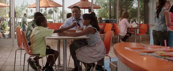 Movie still from “The House” (2017), directed by Andrew Jay Cohen – A man sitting at a table with a little girl; Medium shot, Over the shoulder angle