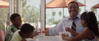 Movie still from “The House” (2017), directed by Andrew Jay Cohen – A man and a woman sitting at a table with two cups; Medium shot, Over the shoulder angle