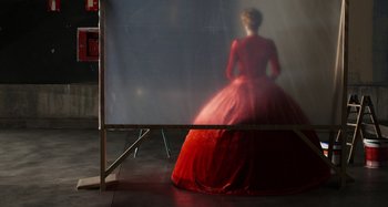 Movie still from “The Human Voice” (2020), directed by Pedro Almodóvar – A woman in a red dress standing in front of a mirror; Wide shot, Over the shoulder angle
