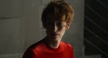Movie still from “The Human Voice” (2020), directed by Pedro Almodóvar – A woman in a red shirt is looking at the camera; Close Up shot, Low angle