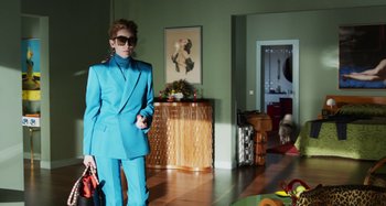 Movie still from “The Human Voice” (2020), directed by Pedro Almodóvar – A woman in a bright blue suit stands in a living room; Wide shot, Over the shoulder angle