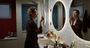 Movie still from “The Human Voice” (2020), directed by Pedro Almodóvar – A woman is in the bathroom brushing her teeth in front of a mirror; Medium shot, High angle