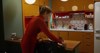 Movie still from “The Human Voice” (2020), directed by Pedro Almodóvar – A woman in a red dress standing at a counter; Medium shot, Low angle