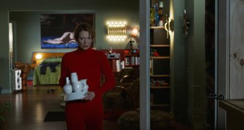 Movie still from “The Human Voice” (2020), directed by Pedro Almodóvar – A woman in a red outfit holding a white object; Medium shot, Over the shoulder angle