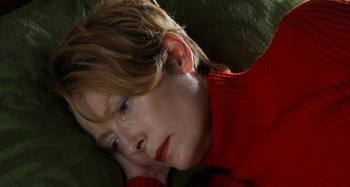 Movie still from “The Human Voice” (2020), directed by Pedro Almodóvar – A person laying on a couch; Close Up shot, High angle