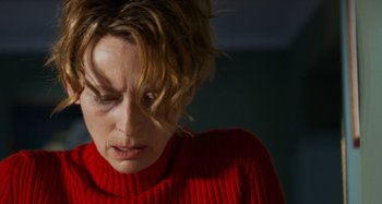 Movie still from “The Human Voice” (2020), directed by Pedro Almodóvar – A person wearing a red sweater; Close Up shot, Low angle