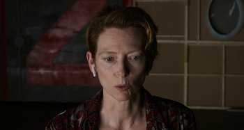 Movie still from “The Human Voice” (2020), directed by Pedro Almodóvar – A woman with a white ear piece is looking at the camera; Close Up shot, Over the shoulder angle